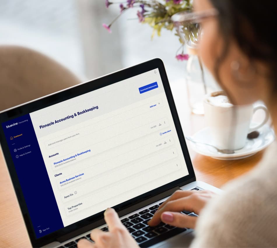 Over-the-shoulder of accountant looking at Bluevine Accountant Dashboard on her laptop.