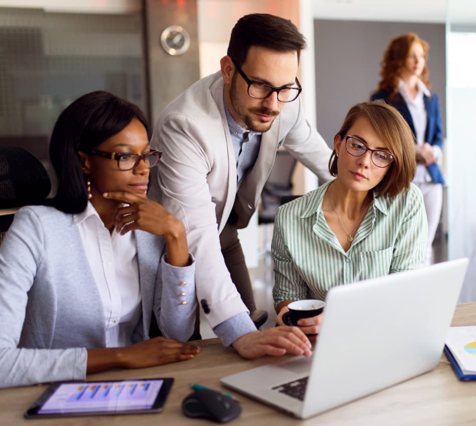 Manager and team collaborate on laptop.