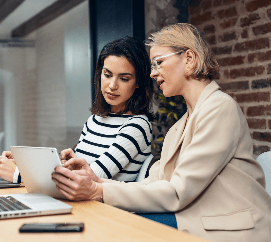 Two businesswomen review company payroll.