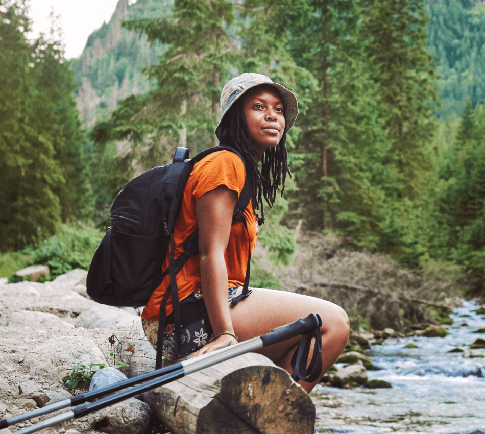 A business owner enjoys a hike along a river during a vacation.