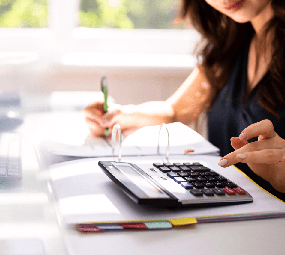 Close-up of an entrepreneur using a calculator to track her business finances.