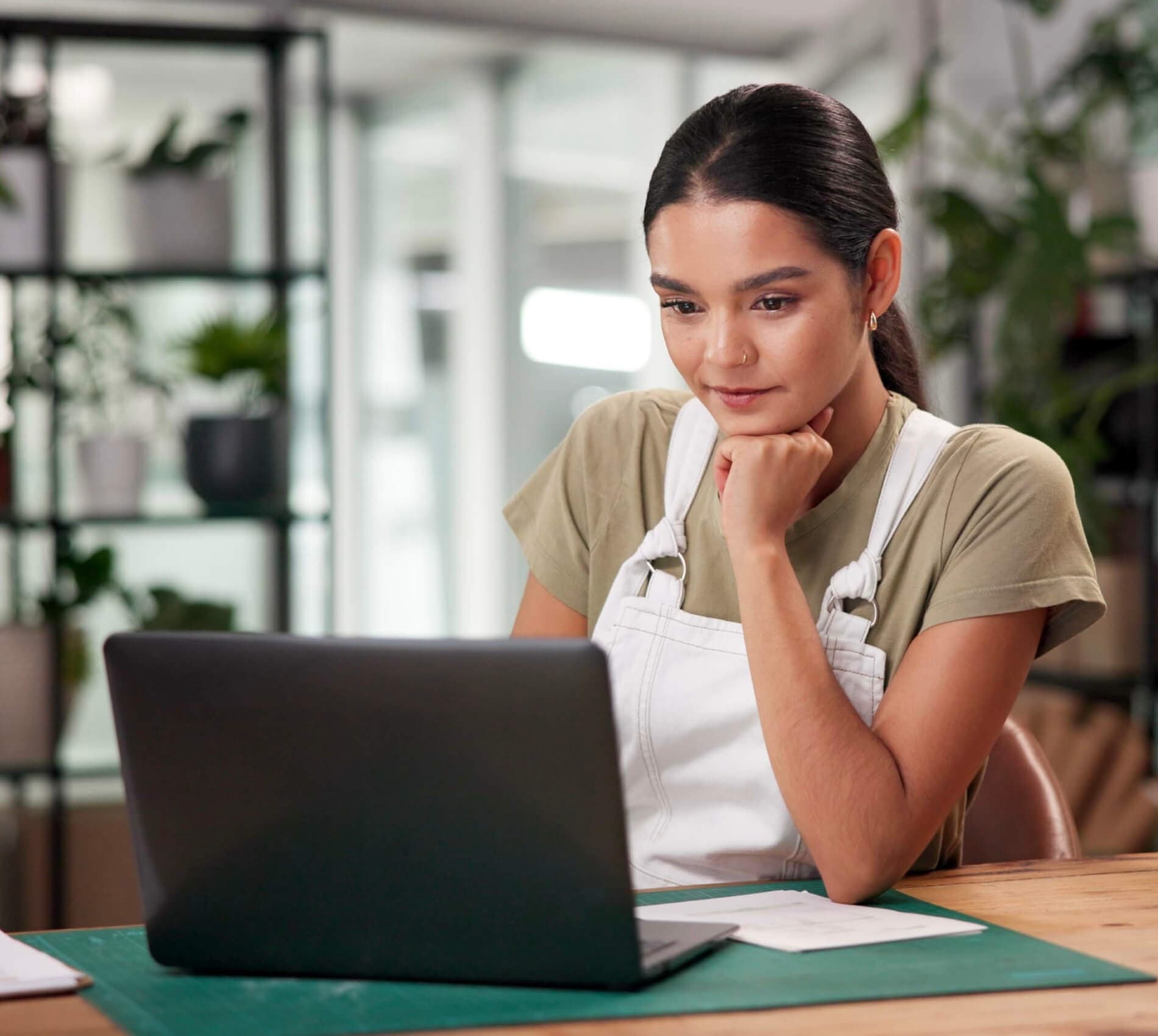 Small business owner reviewing AI tools on a laptop at their workspace