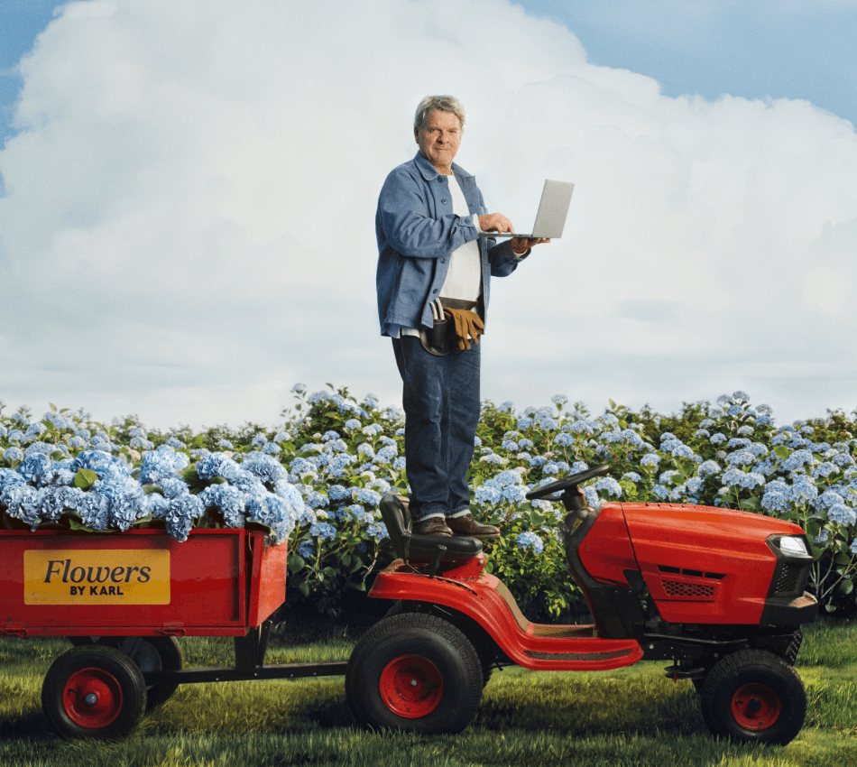 Small business owner stands on a tractor to show how Bluevine makes business banking easier done than said.