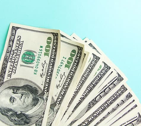 Image of $100 bills fanned out on a table | Bluevine