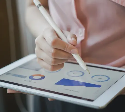 Image of woman holding her tablet and looking at business analytics.