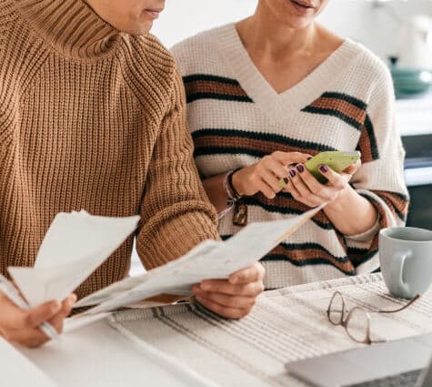 Closeup of two business partners sitting down and doing their taxes or managing their books