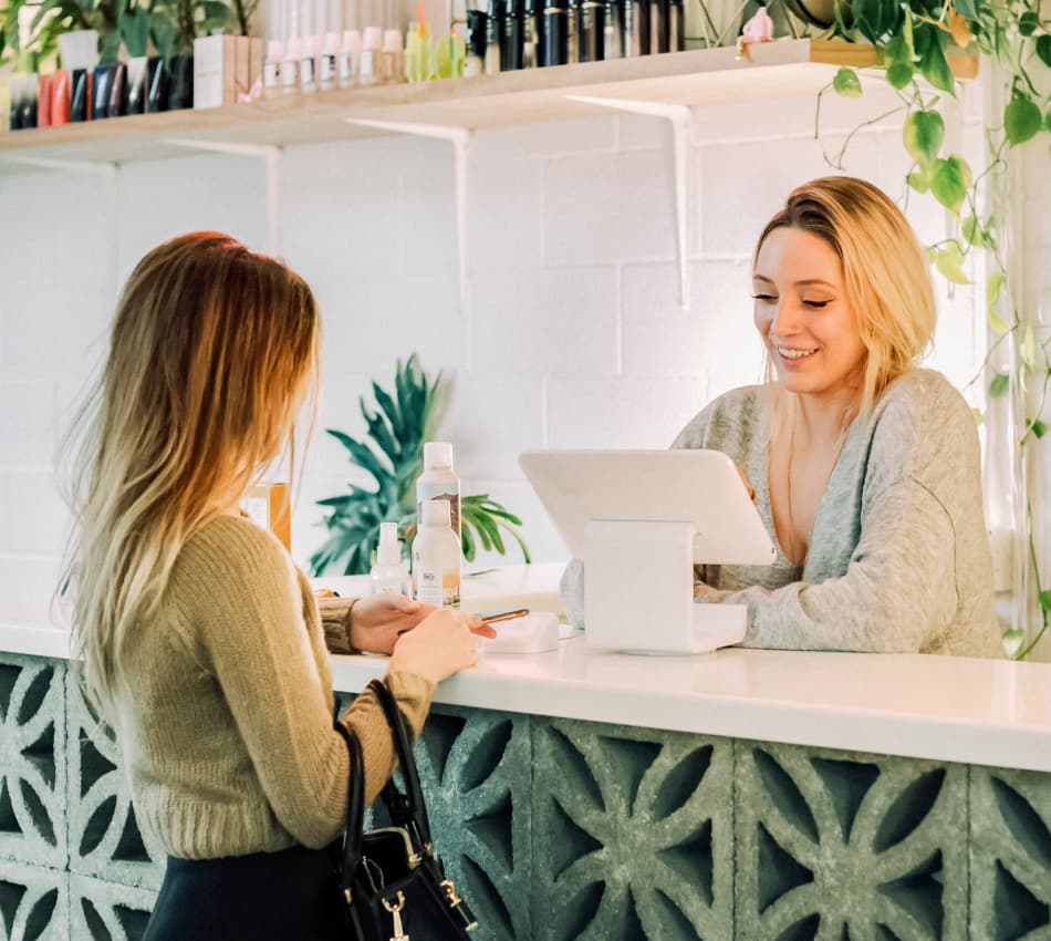 Retail store employee helps customer complete purchase using a simple point-of-sale (POS) system.