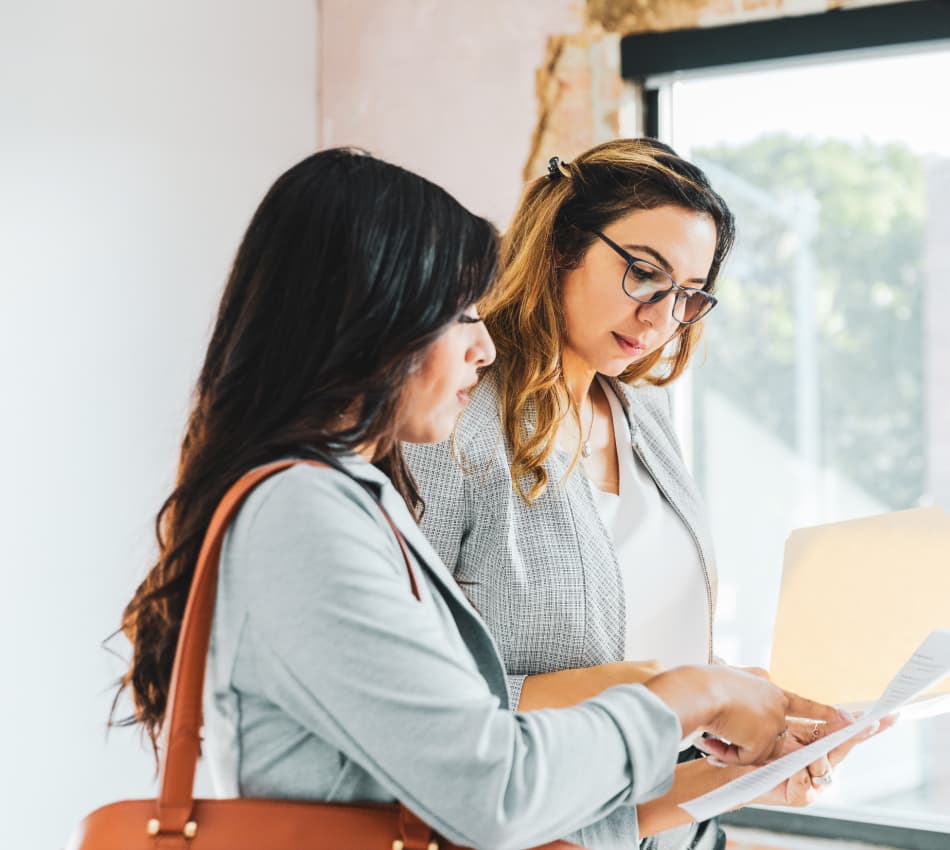 Female business owner reviews lease agreement terms with her landlord.