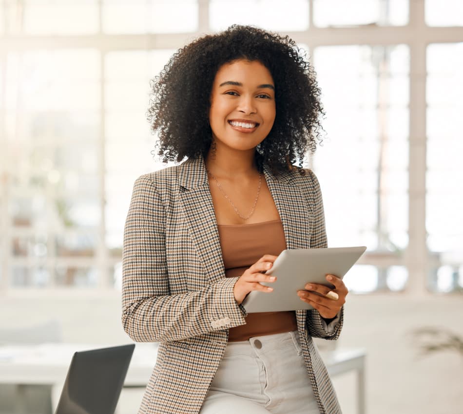 Female business owner holds a tablet in office.