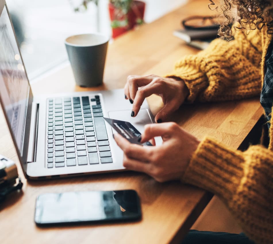 Close-up of female business owner making a purchase on her laptop with a business credit card.