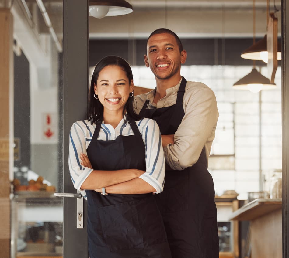 Two family members stand in the doorway of their coffee shop business.