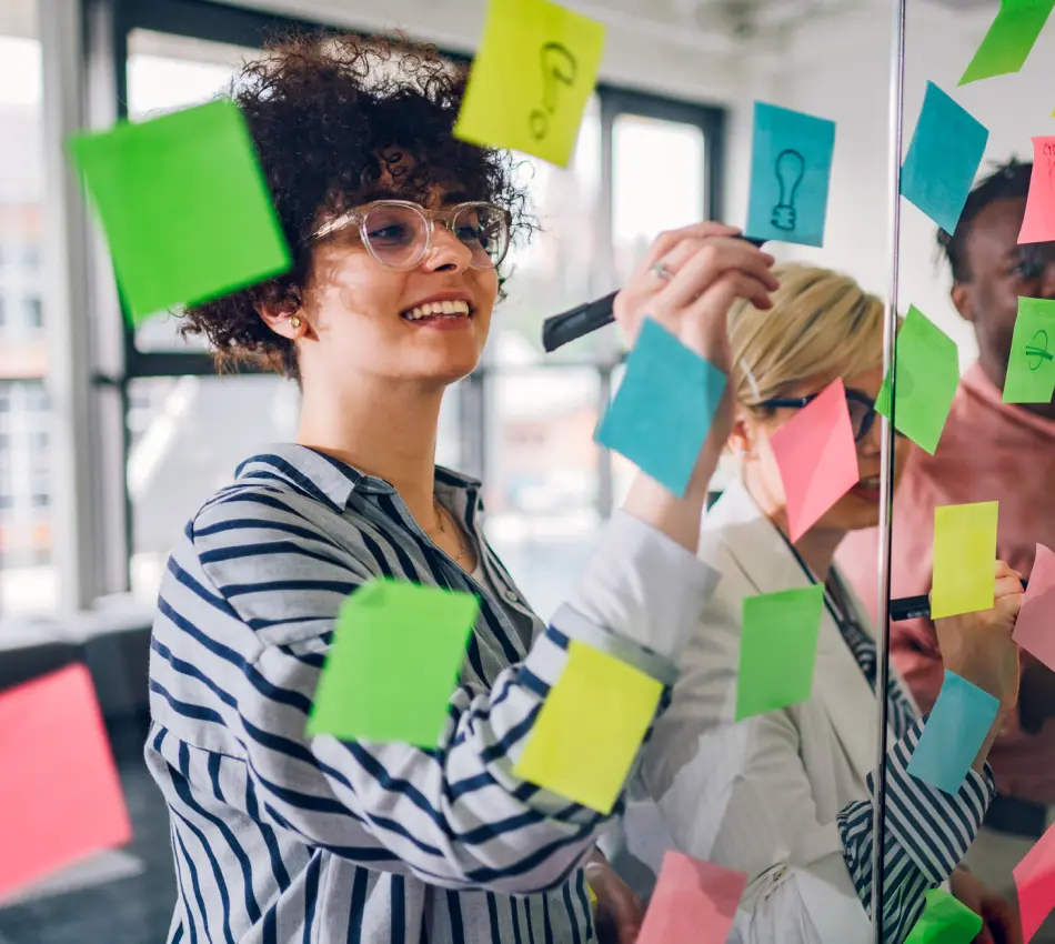 Small business employees brainstorm marketing strategies on colorful sticky notes.