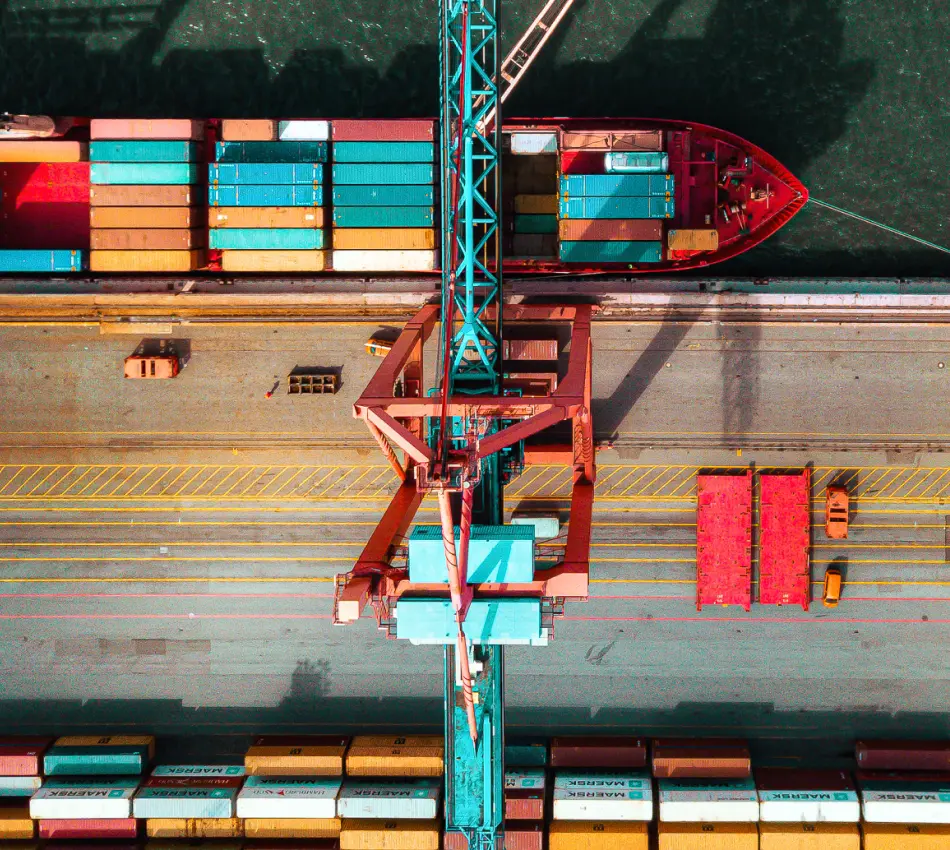 Bird's eye view of a cargo ship being loaded with freight containers.