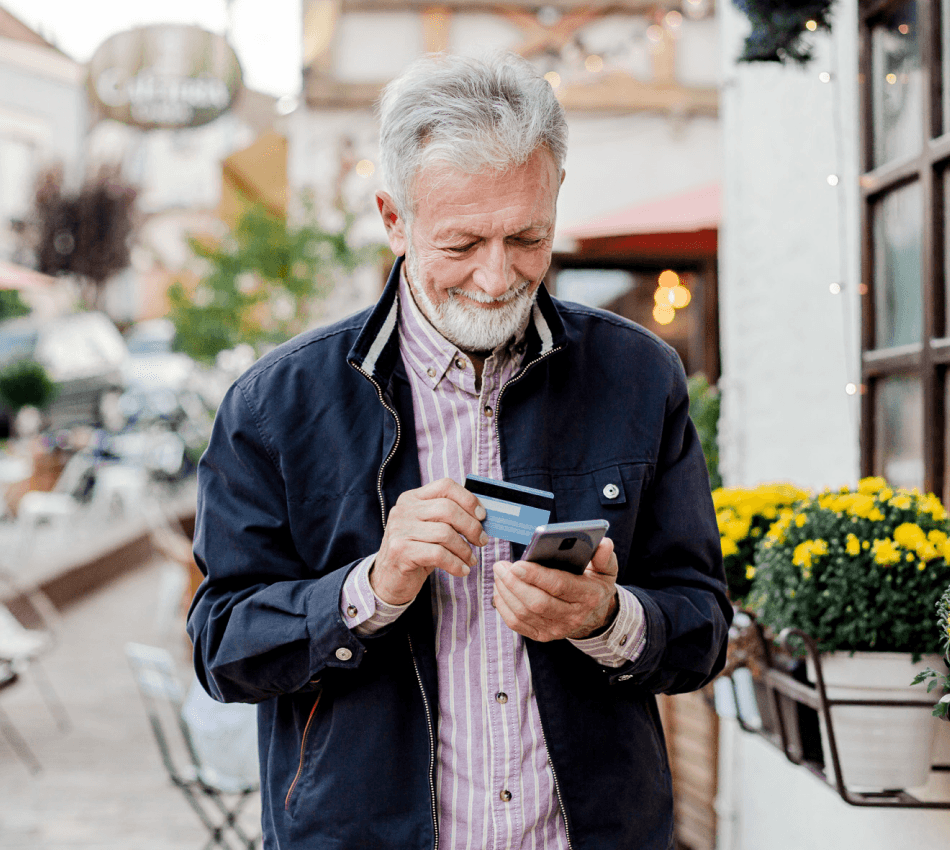 A small business owners makes a purchase with his business credit card from his phone.