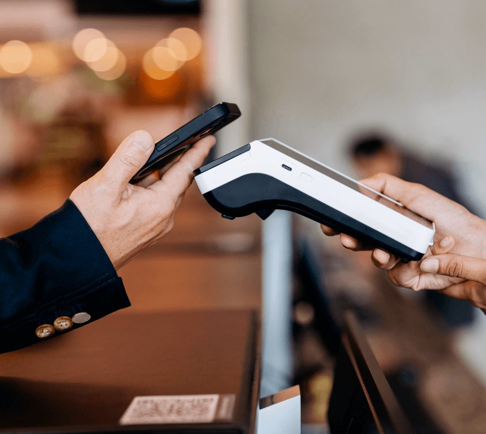 Close-up of a customer using tap-to-pay technology to make a purchase with their phone.