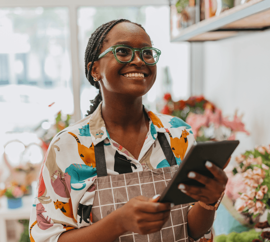 Small business owner uses a tablet to take inventory for her flower shop.